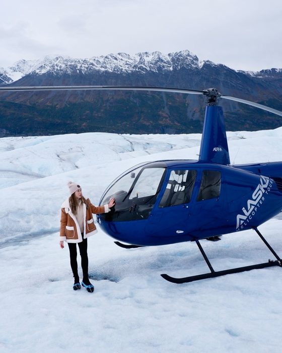 Angelika next to a helicopter on a glacier in Alaska