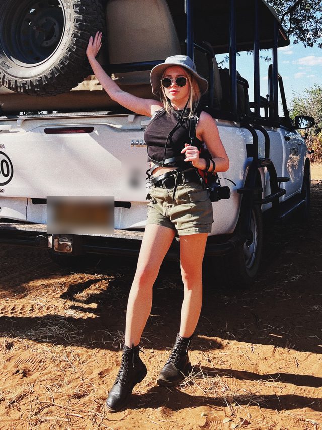 Angelika with a camera next to a safari jeep